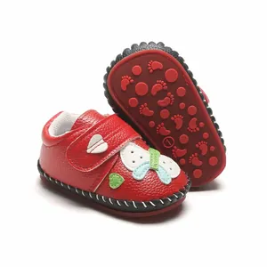 Gros plan de chaussures de marche rouges pour bébé avec cuir texturé et semelle souple