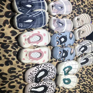 Detailed overhead view of multiple baby sock shoes with varied patterns and soft soles