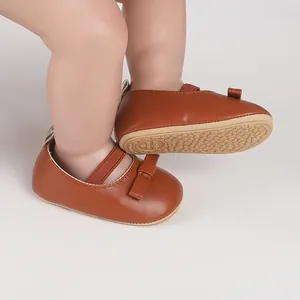 Détail en gros plan des chaussures de marche Mary Jane marron pour bébé avec un nœud
