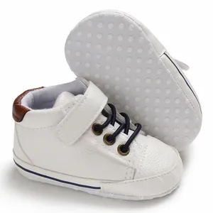 Detailed view of white high-top leather baby walking shoes with soft dot-patterned soles