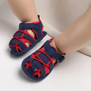 Dettaglio di sandali per neonati blu navy e rossi a punta chiusa con suole molto morbide