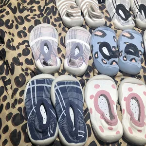 Detailed view of various patterned non-slip baby walker sock shoes on leopard background