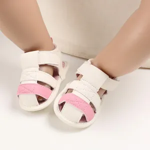 Detailed view of baby summer sandals with soft soles in a white and pink color scheme