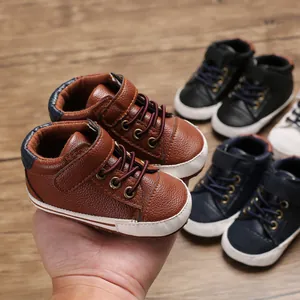 Detailed view of brown faux leather high-top baby walking shoes with soft white soles