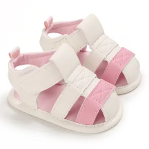 Detailed view of pink and white soft-soled baby summer sandals with hook-and-loop straps