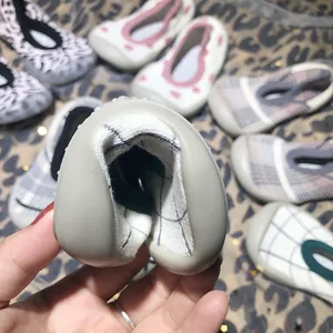 Detail view showing the flexibility of soft-soled baby socks shoes for toddlers.