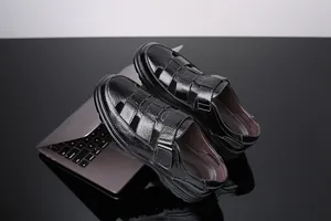 Detalle de sandalias de cuero negro para hombre, transpirables con cierre de velcro.