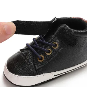 Close-up of black leather baby walking shoe showing the adjustable velcro strap