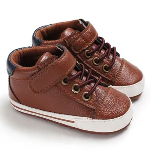 Close-up view of brown high-top leather baby walking shoes with soft soles and laces.