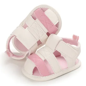 Close-up detail of pink and white baby sandals with soft soles and heart heel tabs
