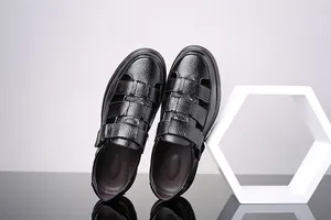 Detalle de sandalias de cuero genuino negro para hombre con diseño calado y cierre de velcro.