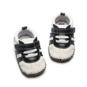 Vue de dessus de chaussures de marche pour bébé à semelle souple en blanc et noir