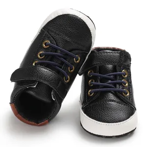 Detailed view of black faux-leather high-top baby shoes with soft soles and velcro straps