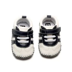 Vue de dessus de chaussures de marche pour bébé en cuir blanc avec sangles bleu marine