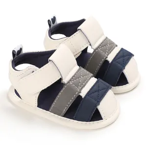 Close-up view of soft-sole baby walking sandals featuring navy and grey patchwork design