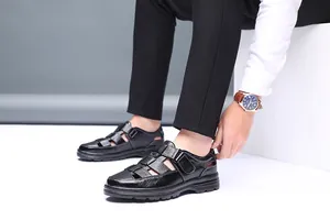 Primer plano de sandalias informales de cuero negro para hombre con diseño calado.