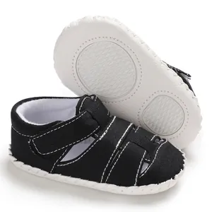 Vista dettagliata di sandali per neonati in tela nera con suola in gomma bianca antiscivolo