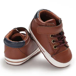 Detail view of brown faux leather high-top baby walking shoes with soft white soles.