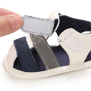 Close-up view of the adjustable hook-and-loop strap on soft-soled baby sandals