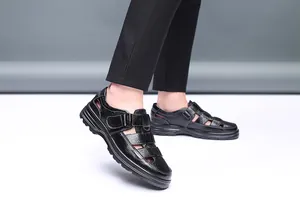 Detalle de sandalias de cuero negro para hombre con velcro y diseño calado transpirable