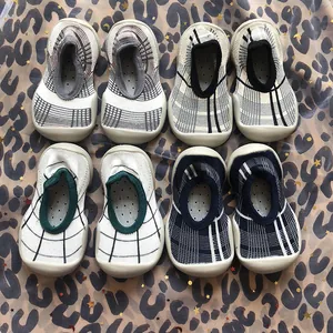 Multiple pairs of patterned baby sock shoes with non-slip rubber soles on leopard fabric