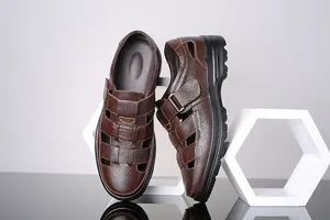 Detalle de sandalias de cuero genuino marrón para hombre con moderno diseño calado.