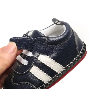 Gros plan d'une chaussure de marche bébé en similicuir bleu marine avec scratch