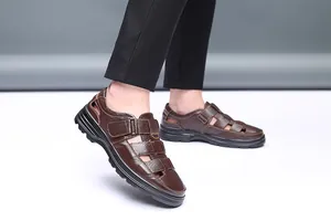 Vista detallada de sandalias de cuero marrón para hombre con cierre de velcro calado