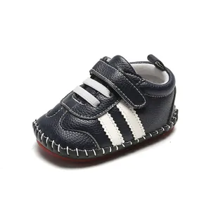 Gros plan de chaussures bébé bleu marine avec semelle en caoutchouc rouge et bande velcro