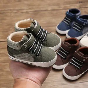 Nahaufnahme von grünen hohen Baby-Lauflernschuhen mit weicher Sohle in einer Hand
