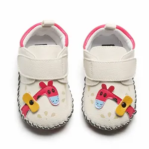 Vue détaillée de chaussures de marche pour bébé avec semelle souple et motif girafe.