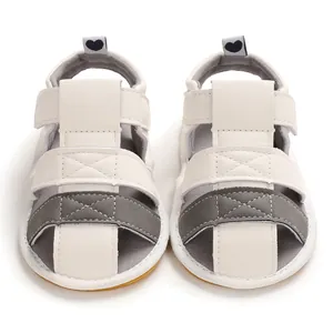 Front view of minimalist white and grey soft-soled infant summer sandals with heart detail