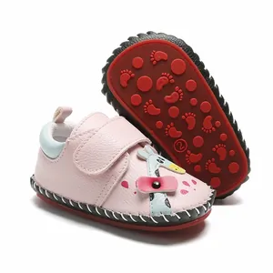Vue détaillée de chaussures de marche bébé roses avec semelle en caoutchouc et girafe