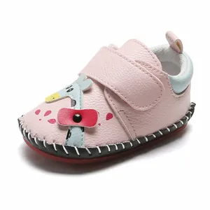 Gros plan sur chaussure bébé rose avec applique girafe mignonne et fermeture par velcro