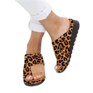 Primo piano di sandali leopardati con anello per alluce e suola platform spessa