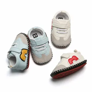 Vue détaillée des semelles en caoutchouc souple et du design M sur chaussures bébé