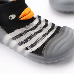 Primo piano del tessuto a rete traspirante e dettaglio pinguino su scarpe da bimbo