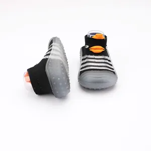 Dettaglio scarpe calzino neonato traspiranti a righe con simpatico pinguino