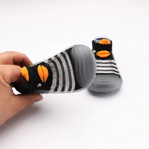 Dettaglio scarpe primi passi neonato a righe con suola in gomma morbida antiscivolo