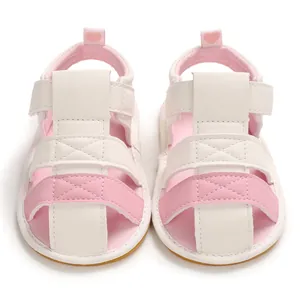 Front view of soft-sole white and pink baby sandals with adjustable velcro straps.