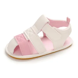 Close-up detail of pink and white soft-soled summer baby sandals with Velcro strap