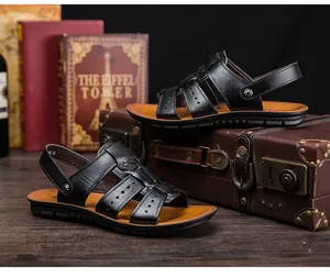 Detalle de sandalias de cuero negro para hombre con correas perforadas sobre maleta vintage