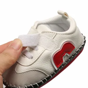 Vue rapprochée d'une chaussure bébé à semelle souple avec détail de sangle velcro réglable