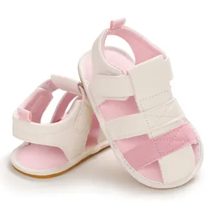 Detail of soft-soled pink and white baby sandals with secure velcro straps.