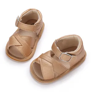 Champagne gold baby girl walking sandals with metallic cross straps and soft soles.
