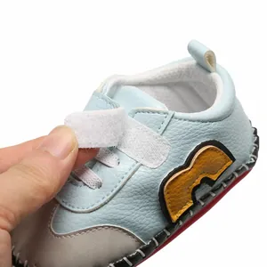 Gros plan d'une chaussure de bébé avec fermeture velcro et texture cuir souple