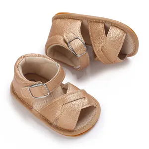 Detailed close-up of champagne gold baby girl sandals with soft rubber soles and pebble texture