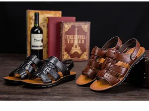 Sandalias clásicas de cuero para hombre en negro y marrón sobre mesa de madera.