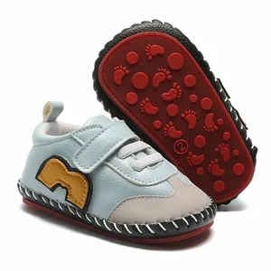 Vue détaillée de chaussures de marche pour bébé montrant le côté bleu et la semelle rouge.