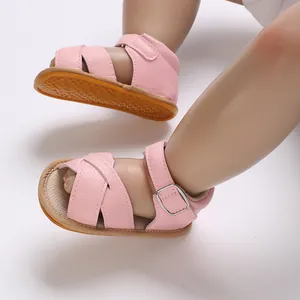 Close-up of pink baby girl walker sandals with soft rubber sole and buckle strap
